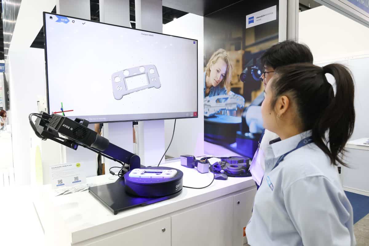 ผู้เข้าชมงานดูการทำงานของ ZEISS ScanPort ขณะสแกนชิ้นงานจริง