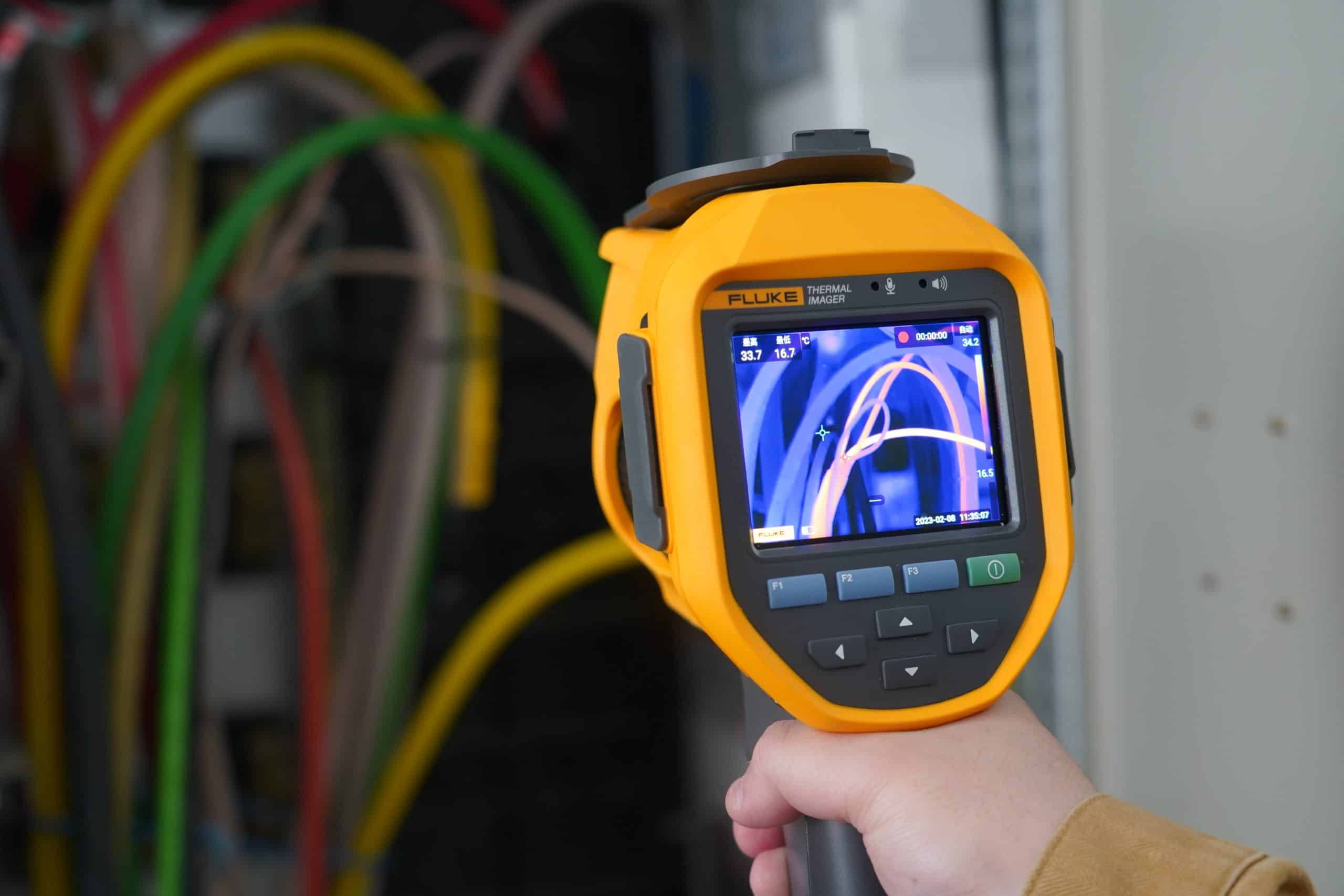 หน้าจอแสดงผลของกล้องถ่ายภาพความร้อน Fluke ขณะตรวจวัดอุณหภูมิสายไฟภายในตู้คอนโทรล โชว์ภาพอินฟราเรดที่ระบุความร้อนสะสมในแต่ละเส้นได้อย่างชัดเจน