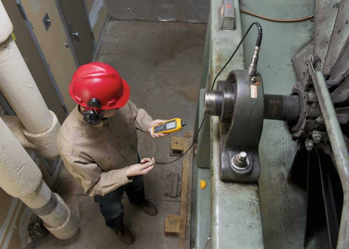 ช่างเทคนิคใช้เครื่องวัดความสั่นสะเทือน Fluke ตรวจสอบสุขภาพตลับลูกปืนมอเตอร์อุตสาหกรรม