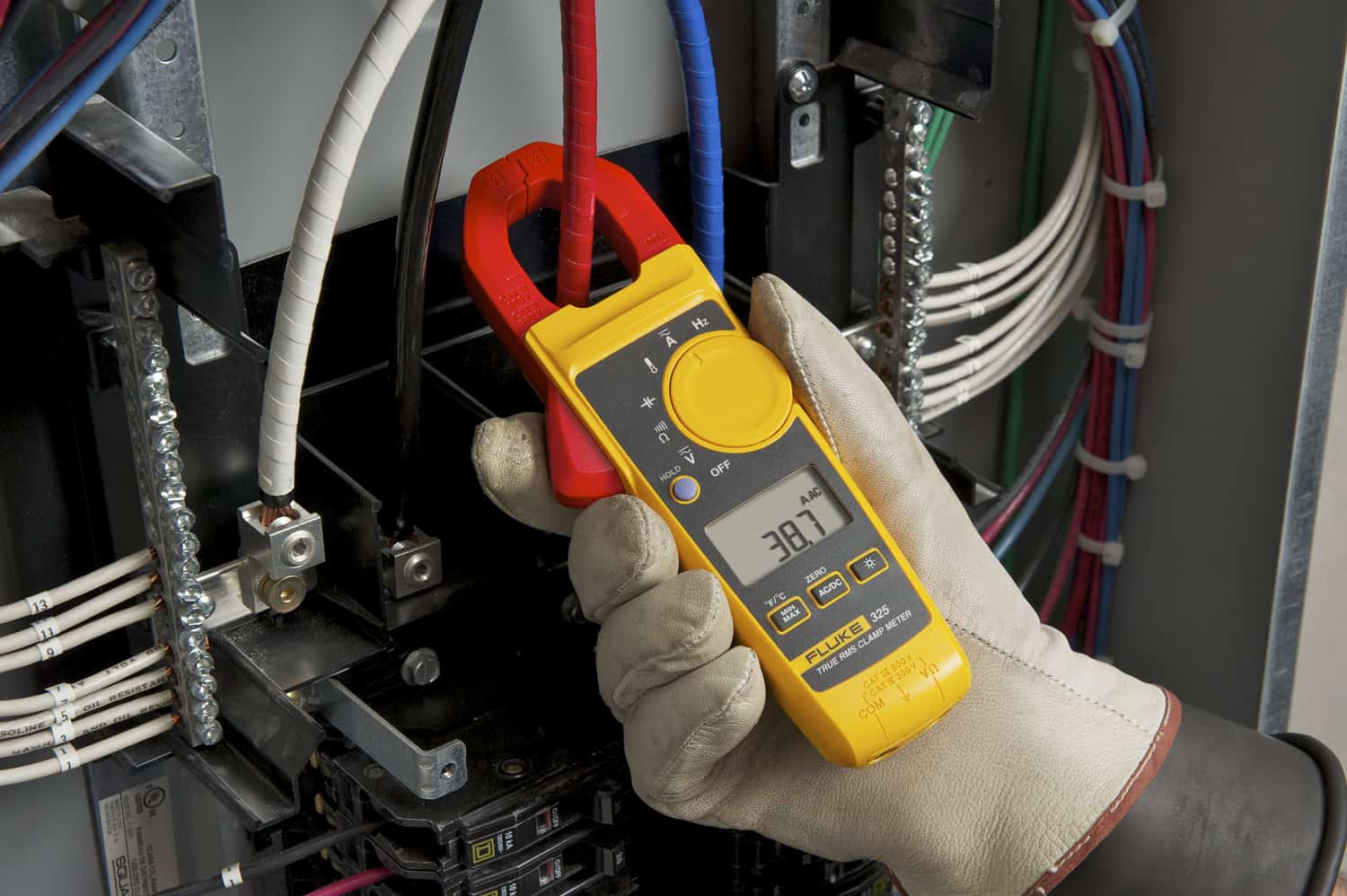 Fluke 325 True-RMS clamp meter measuring electrical current in an industrial electrical panel
