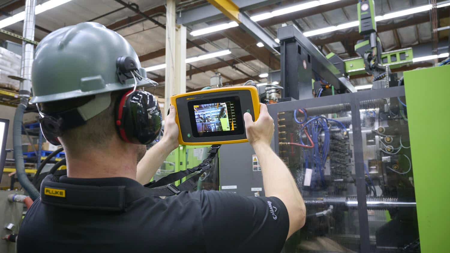 วิศวกรโรงงานใช้กล้องถ่ายภาพเสียง Fluke ii915 ตรวจสอบรอยรั่วและแรงดันในระบบเครื่องจักรขนาดใหญ่เพื่อผสานการทำงานในรูปแบบ Ecosystem Workflow