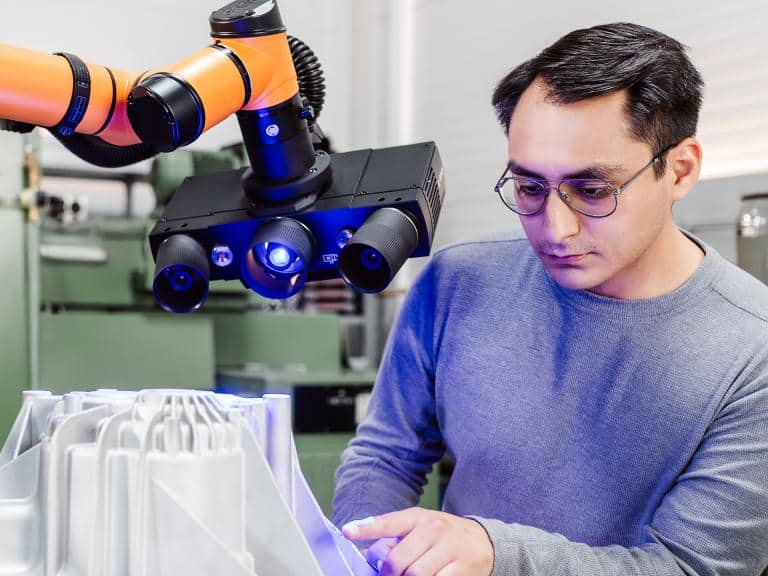 Engineer operating ZEISS ScanCobot automated 3D scan system with ATOS Q sensor for high-precision quality inspection by Factory Max