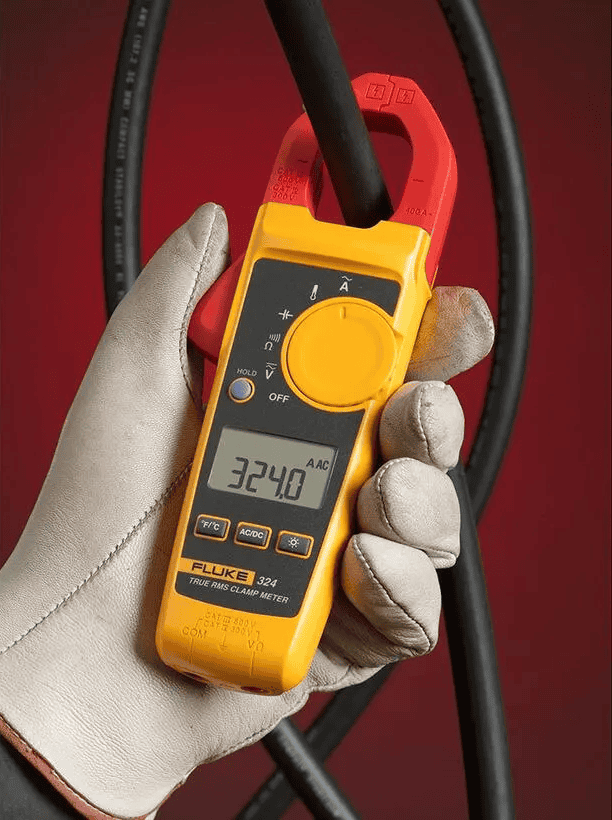 A hand wearing a protective safety glove holding the Fluke 324 True-RMS Clamp Meter measuring AC current on a cable for HVAC testing